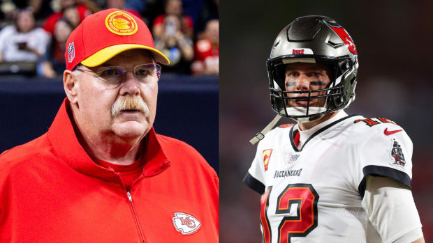 Chiefs coach Andy Reid stands on the sideline. Former Buccaneers quarterback Tom Brady stands on the field.